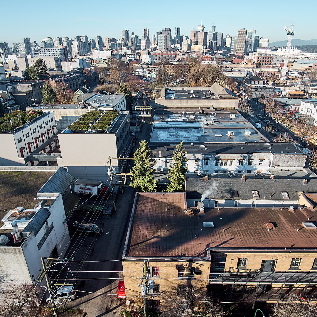 Image capturing Vancouver Downtown Eastside with a backdrop of Downtown Vancouver, skyscrapers, Burrard Inlet and North Shore mountains
