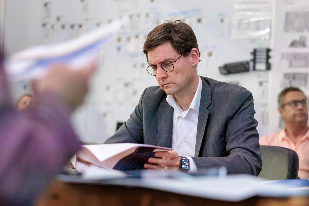 British Columbia's Premier, David Eby, leans over newspaper as province's residents raise more and more concerning questions.