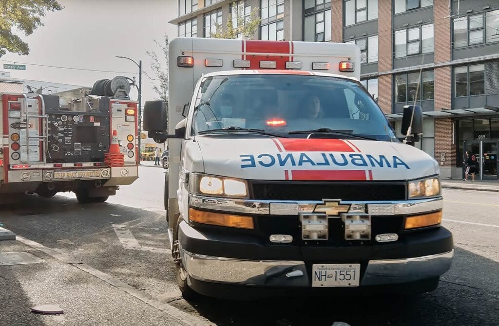 Pictured ambulance with first responders assisting on the streets of Downtown Eastside Vancouver