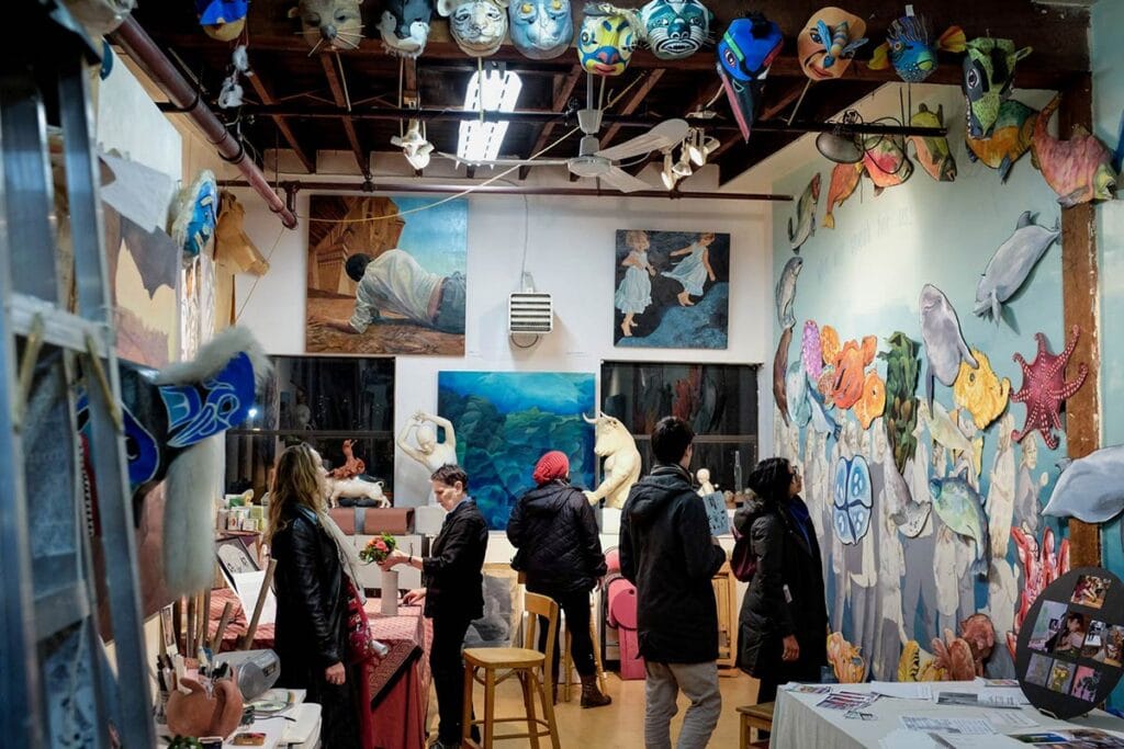 Image captures people looking at the visual arts presented at Eastside Culture Crawl in Vancouver, BC