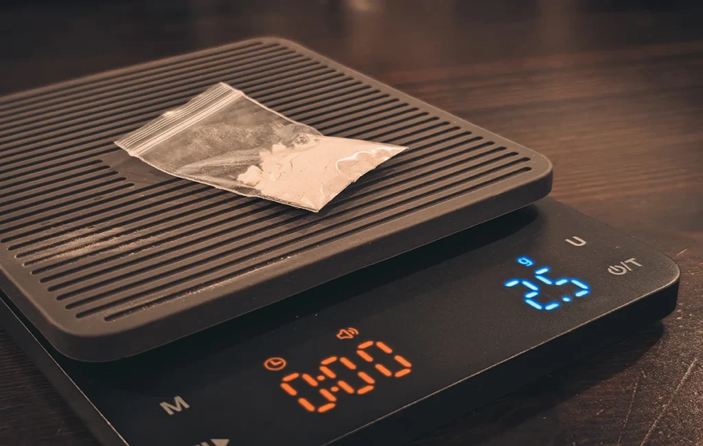 Picture of a table with a scale on it and a small plastic bag with a white substance on the top