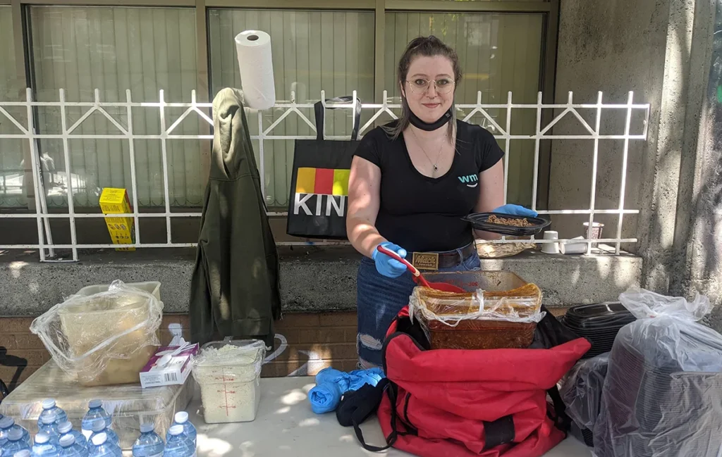 Image of a volunteer serving meals to people in need at Downtown Eastside Vancouver