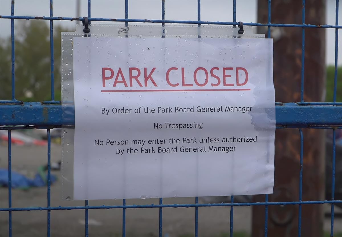 Photo of a sign on the fence of Vancouver's Crab Park homeless encampment telling that the park is closed by the order of the Park Board General Manager