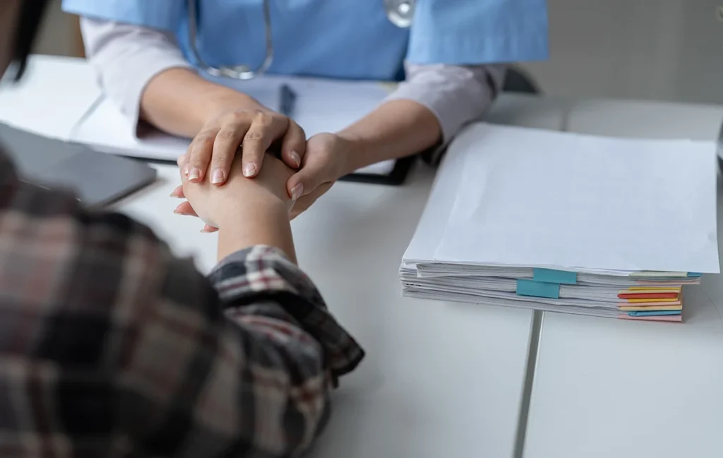 A picture of doctor holding hand of a teenage patient in hospital environment